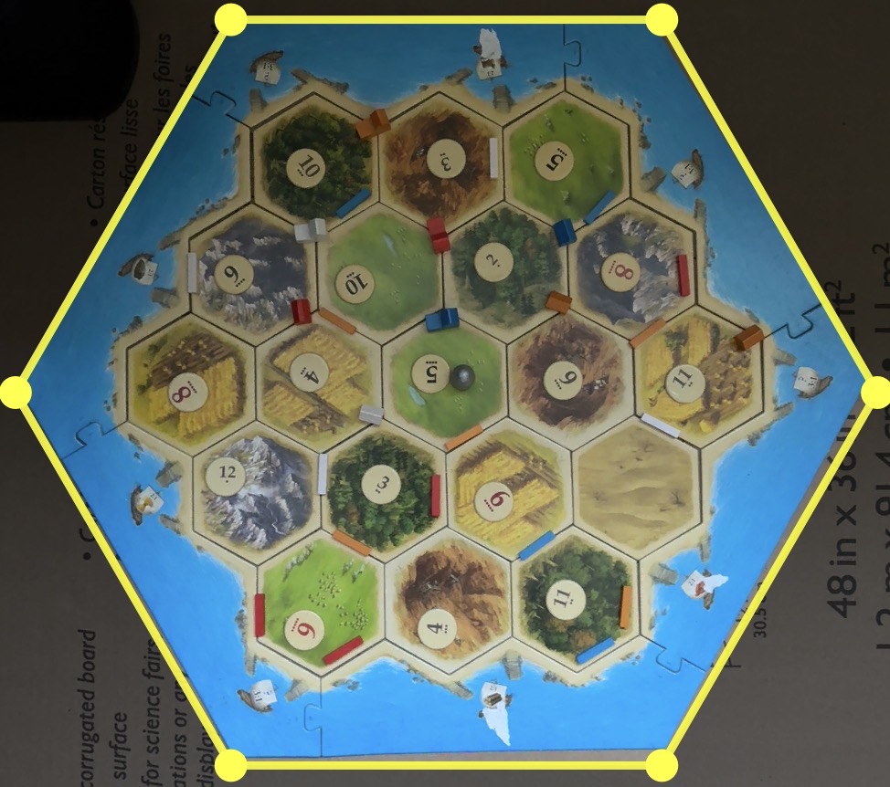 Camera view with a yellow hexagon guide lined up over a physical hex-tile board.